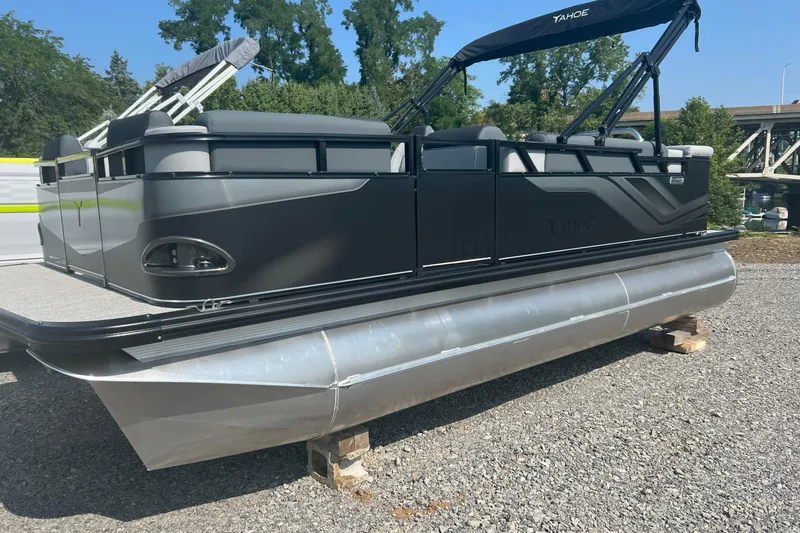 Slide: The Image of 2026 Tahoe Pontoon 1980 CRUISE boat on gravel, featuring sleek design and modern amenities. - 2