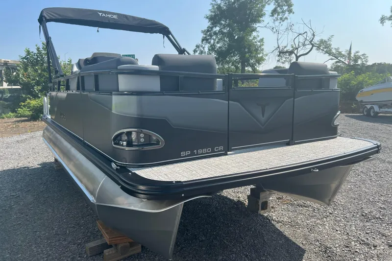 Slide: The Image of 2026 Tahoe Pontoon 1980 CRUISE boat with sleek design, parked outdoors on gravel. - 4