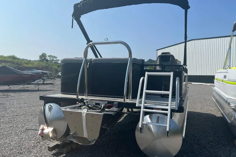 Slide: The Image of 2026 Tahoe Pontoon 1980 CRUISE boat with ladder, parked outdoors on gravel. - 7
