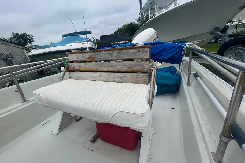 Slide: The Image of 1993 Boston Whaler 17 Montauk boat interior with weathered bench seat and marine equipment. - 6