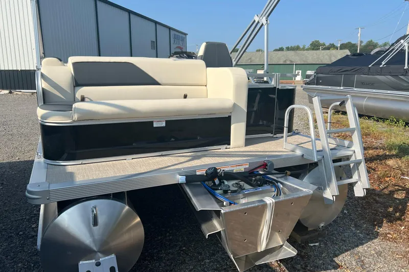 Slide: The Image of 2026 Tahoe Pontoon 1780 CRB with seating and ladder, parked outdoors. - 4