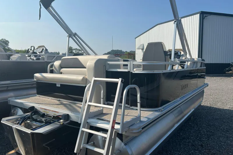 Slide: The Image of 2026 Tahoe Pontoon 1780 CRB boat with seating and ladder, parked outdoors. - 6