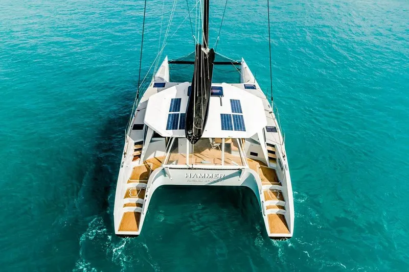 Slide: The Image of 2018 Gunboat 57 catamaran sailing on clear turquoise water, featuring solar panels. - 11