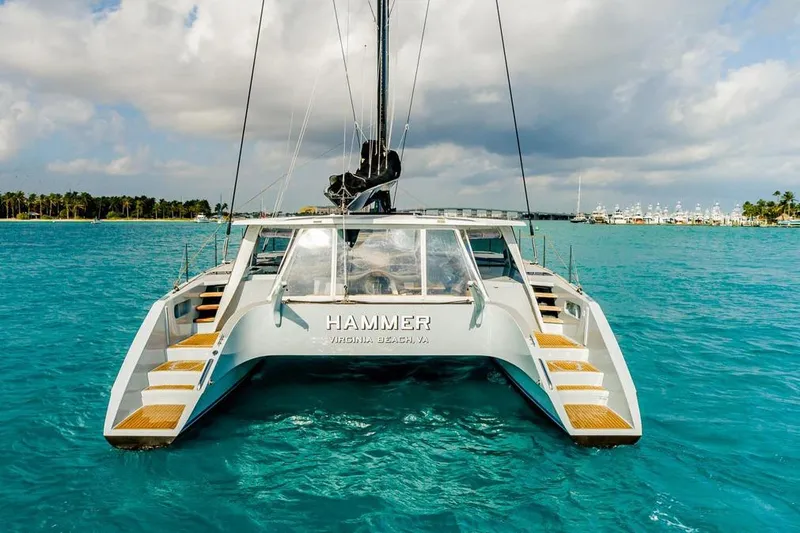 Slide: The Image of 2018 Gunboat 57 catamaran on turquoise water, rear view, with "Hammer" name visible. - 12