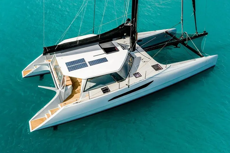 Slide: The Image of 2018 Gunboat 57 catamaran sailing on clear turquoise waters, featuring sleek design and solar panels. - 2