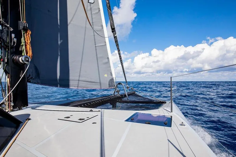 Slide: The Image of Sailing on a 2018 Gunboat 57 catamaran, open sea, clear skies, and vibrant ocean. - 50