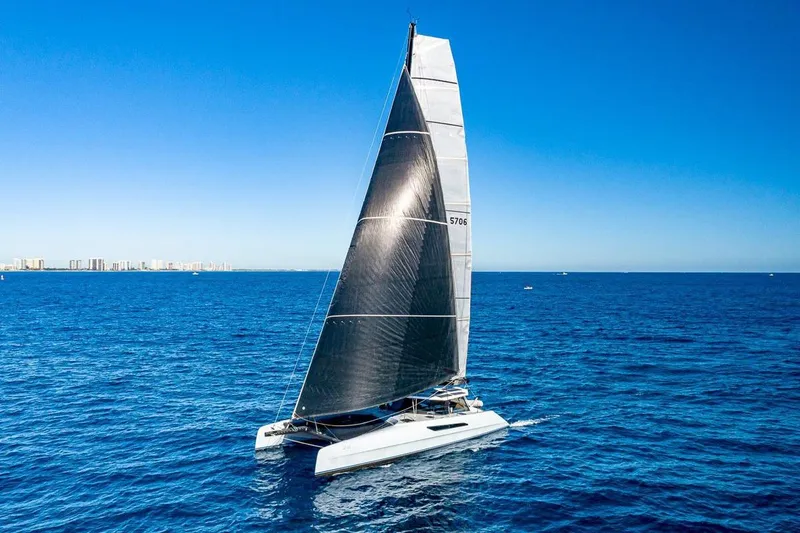 Slide: The Image of 2018 Gunboat 57 sailing catamaran on open ocean with clear blue sky. - 63
