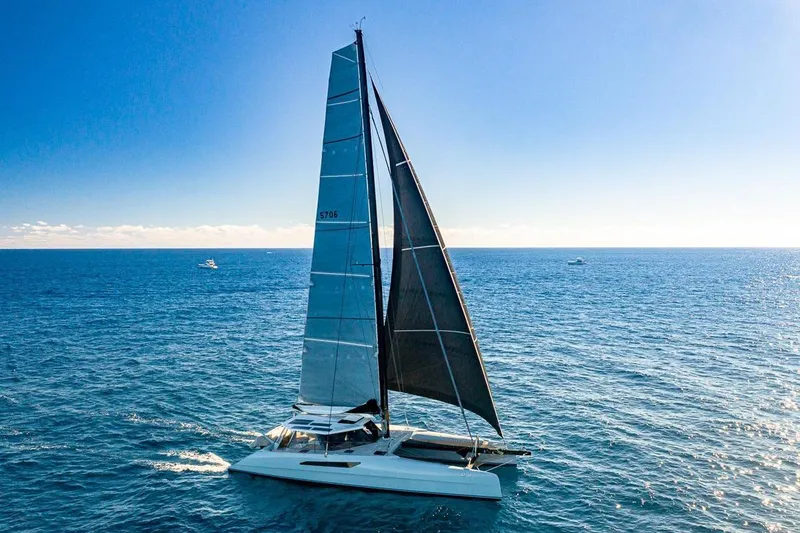 Slide: The Image of 2018 Gunboat 57 sailing catamaran on open ocean under clear blue sky. - 64