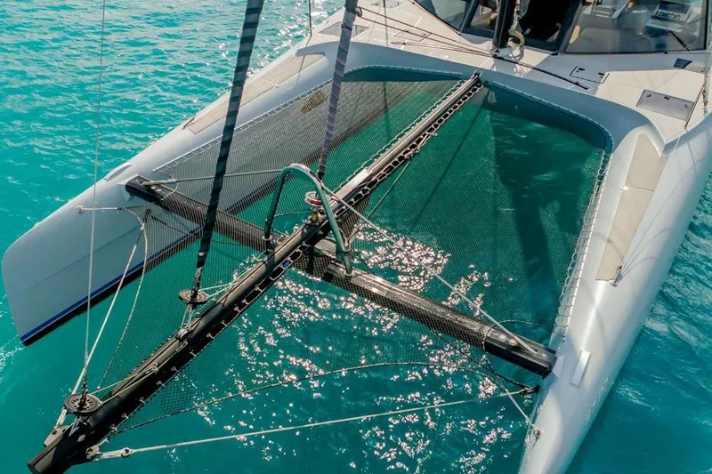 Slide: The Image of 2018 Gunboat 57 catamaran on turquoise water, showcasing sleek design and netting. - 7