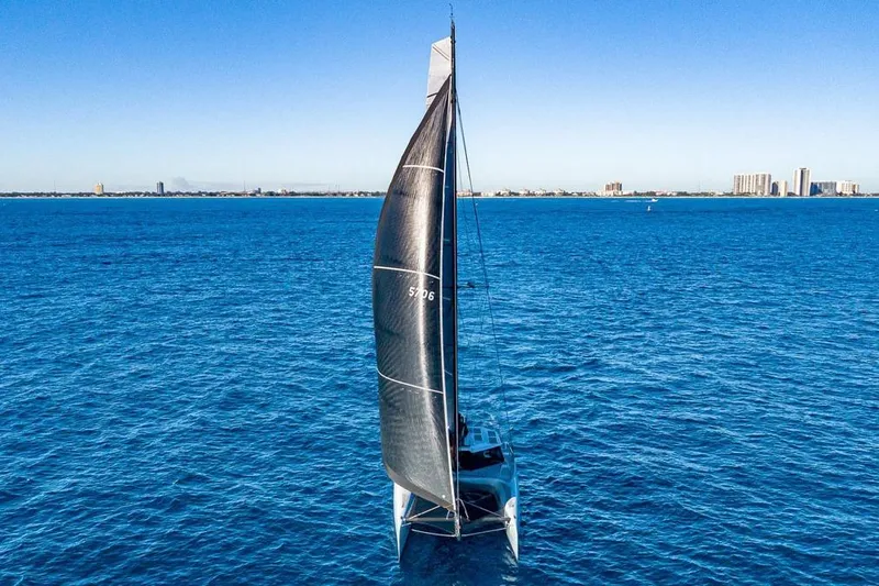 Slide: The Image of 2018 Gunboat 57 sailing on open blue ocean with city skyline in background. - 70