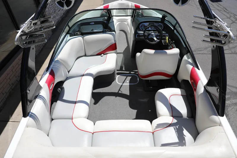 Slide: The Image of 2008 Malibu 21 vRide boat interior with white and red seating, steering wheel, and speakers. - 1