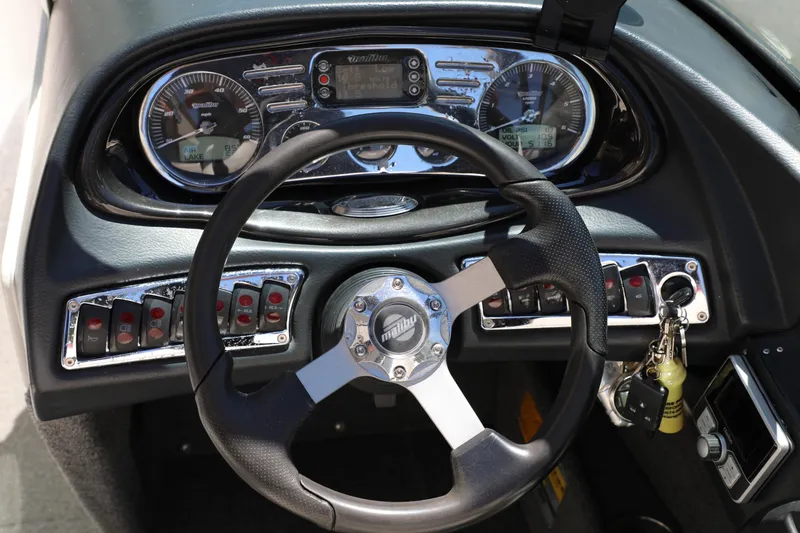 Slide: The Image of Dashboard of a 2008 Malibu 21 vRide boat with steering wheel and controls. - 12
