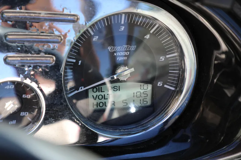 Slide: The Image of Close-up of 2008 Malibu 21 vRide dashboard gauges showing oil pressure, voltage, and hours. - 13