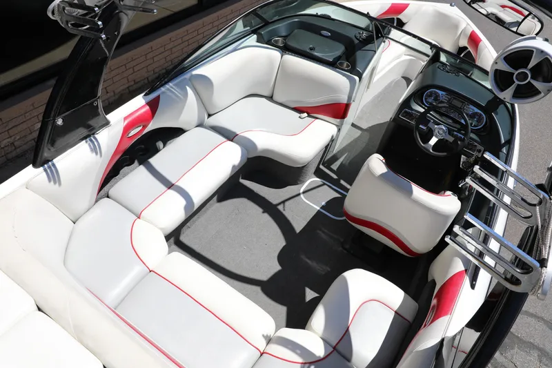 Slide: The Image of 2008 Malibu 21 vRide boat interior with white and red seating, steering wheel, and speakers. - 9