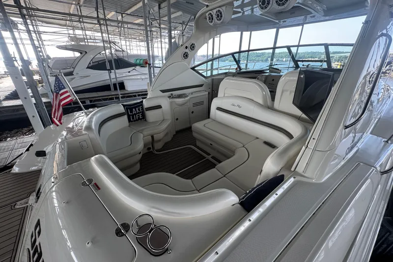 Slide: The Image of 2006 Sea Ray 380 Sundancer interior with plush seating, docked under a covered marina. - 10