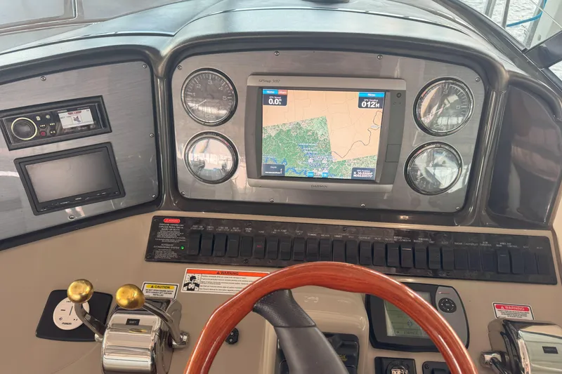 Slide: The Image of Control panel of a 2006 Sea Ray 380 Sundancer with navigation display and gauges. - 11