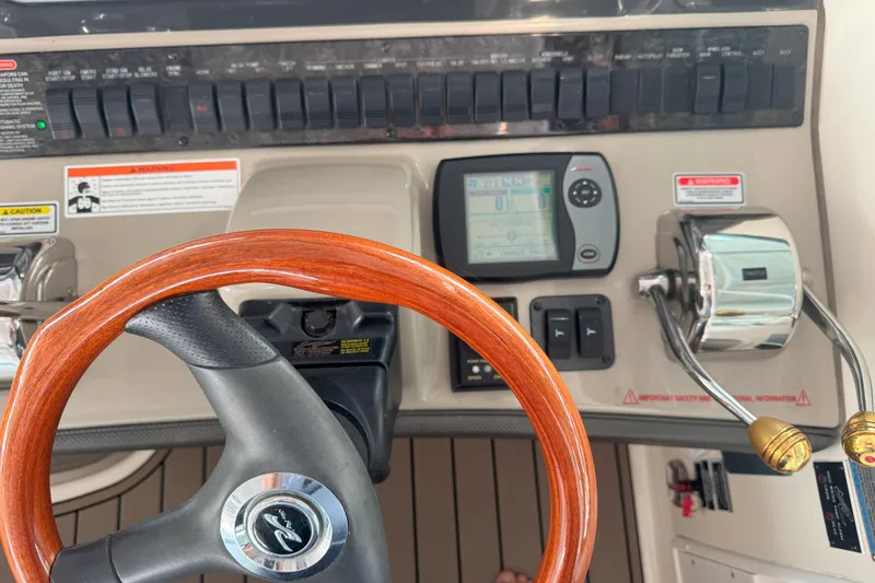 Slide: The Image of Helm of 2006 Sea Ray 380 Sundancer with wooden steering wheel and control panel. - 12