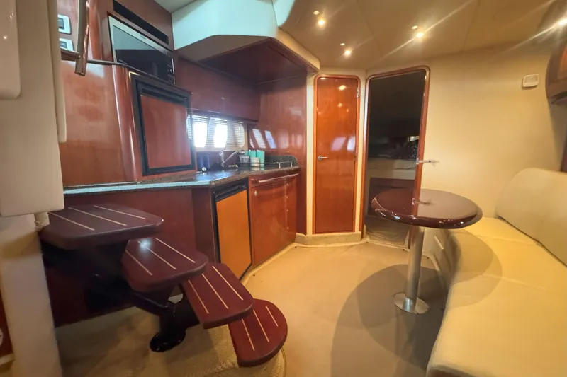 Slide: The Image of Interior of 2006 Sea Ray 380 Sundancer yacht with kitchen, seating, and wooden finishes. - 14
