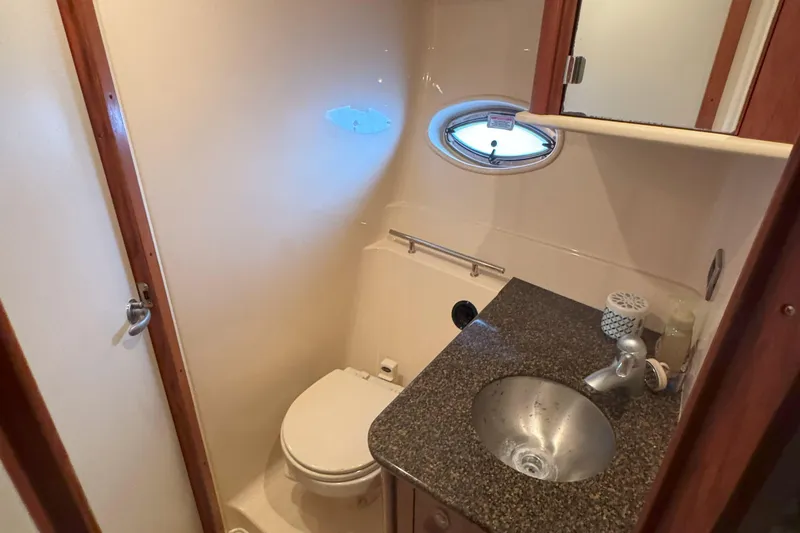 Slide: The Image of Compact bathroom in 2006 Sea Ray 380 Sundancer yacht with sink, toilet, and porthole window. - 21