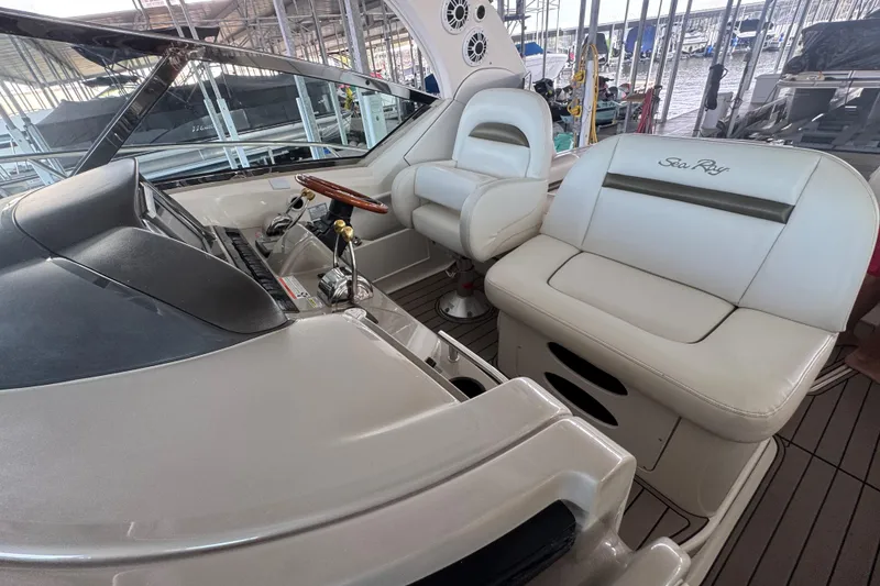 Slide: The Image of 2006 Sea Ray 380 Sundancer cockpit with white seating and wooden steering wheel. - 5