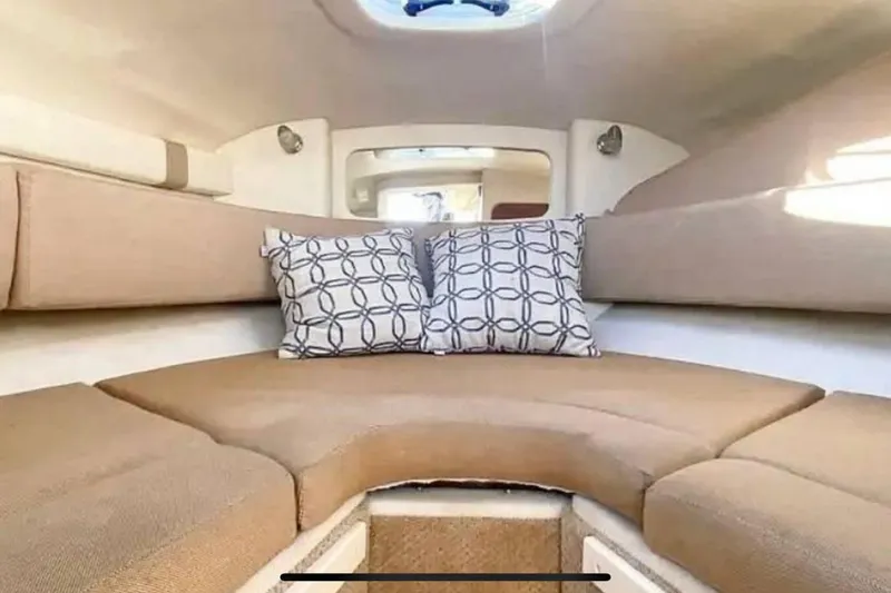 Slide: The Image of Interior cabin of 2011 Sea Ray 240 Sundancer with beige seating and patterned pillows. - 12