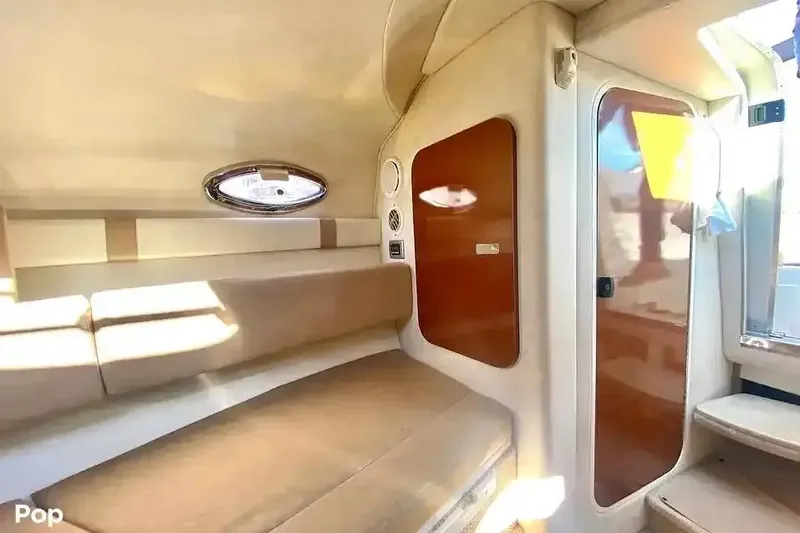 Slide: The Image of Interior cabin of 2011 Sea Ray 240 Sundancer with beige seating and wooden accents. - 16
