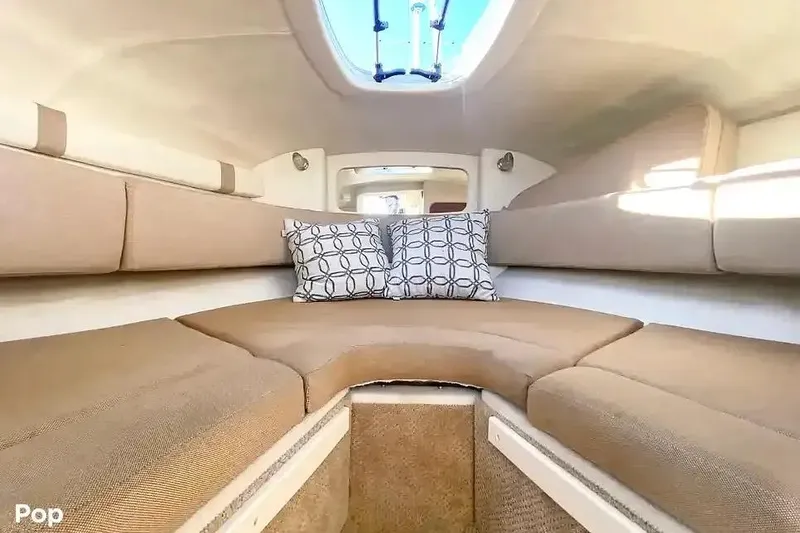 Slide: The Image of Interior cabin of 2011 Sea Ray 240 Sundancer with beige seating and decorative pillows. - 17