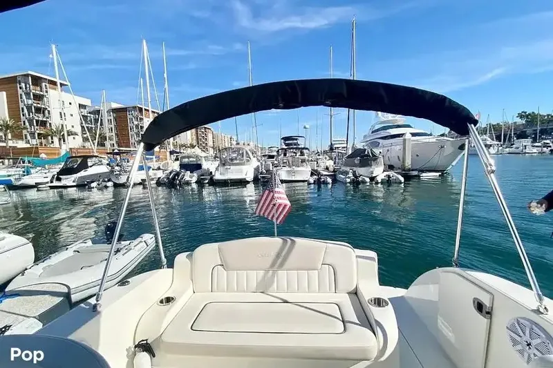 Slide: The Image of 2011 Sea Ray 240 Sundancer in marina, surrounded by boats and clear blue sky. - 2
