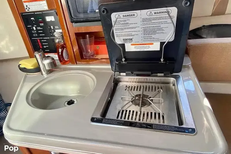 Slide: The Image of 2011 Sea Ray 240 Sundancer kitchenette with sink and stove. - 24