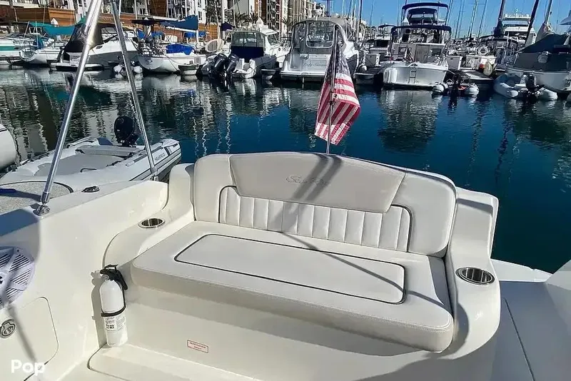 Slide: The Image of 2011 Sea Ray 240 Sundancer boat interior with seating, docked in a marina. - 4
