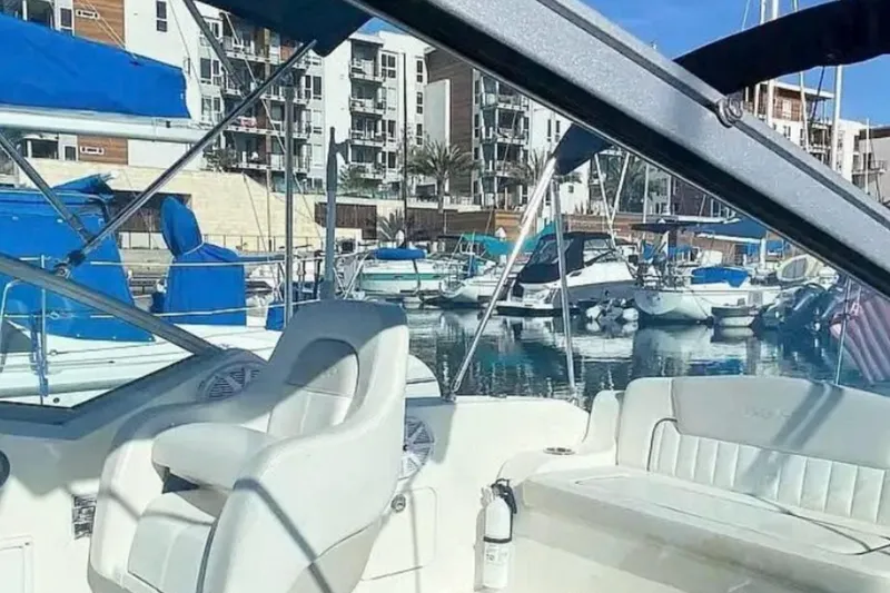 Slide: The Image of 2011 Sea Ray 240 Sundancer interior at marina, surrounded by boats and buildings. - 5