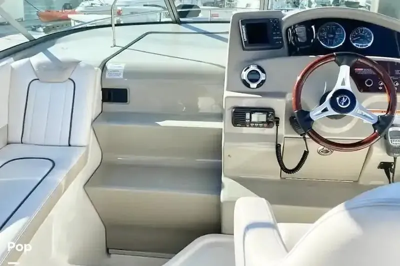 Slide: The Image of Interior view of 2011 Sea Ray 240 Sundancer boat cockpit with steering wheel and seating. - 6