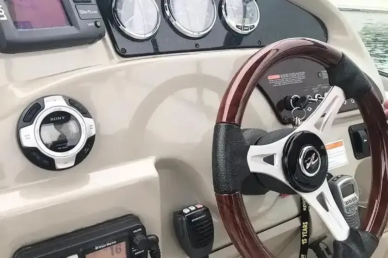 Slide: The Image of Dashboard of a 2011 Sea Ray 240 Sundancer boat with steering wheel and controls. - 7