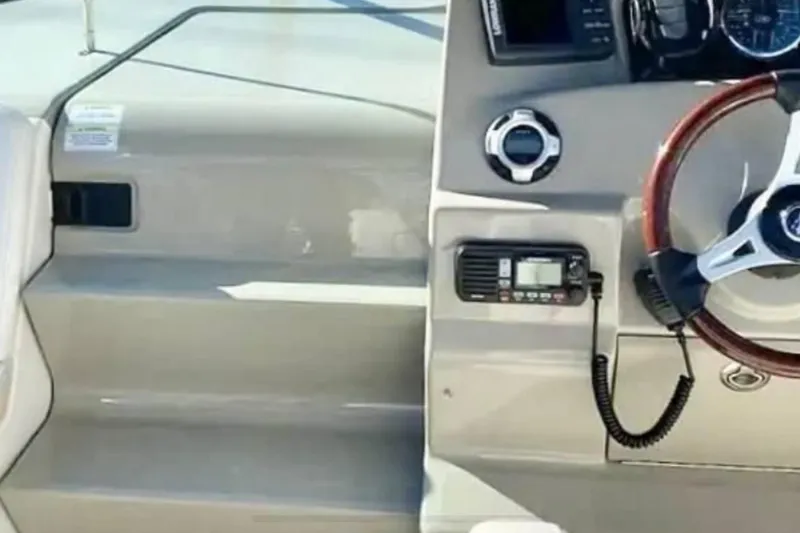 Slide: The Image of 2011 Sea Ray 240 Sundancer boat dashboard with steering wheel and control panel. - 8