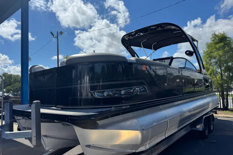 Slide: The Image of 2023 Avalon Excalibur 27' pontoon boat on trailer under blue sky. - 2