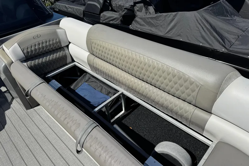 Slide: The Image of 2023 Avalon Excalibur 27' boat interior with open storage compartment and cushioned seating. - 28