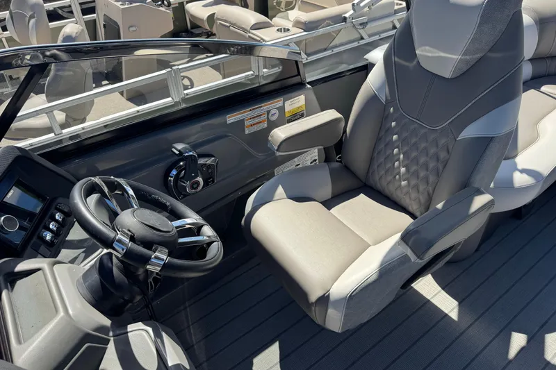 Slide: The Image of 2023 Avalon Excalibur 27' boat interior with steering wheel and captain's chair. - 35