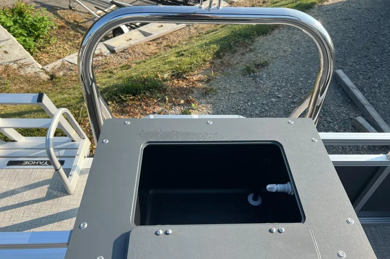 Slide: The Image of 2026 Tahoe Pontoon 2180 REAR FISH boat with open storage compartment and railing. - 23