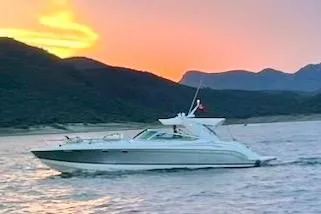 Slide: The Image of 2004 Formula 400 Super Sport yacht cruising at sunset with mountainous backdrop. - 32