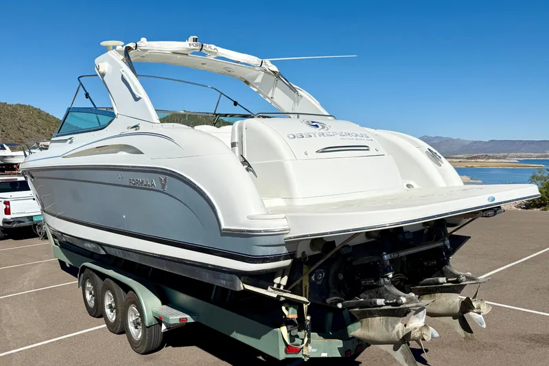 Slide: The Image of 2004 Formula 400 Super Sport boat on trailer, parked near a scenic lake. - 33