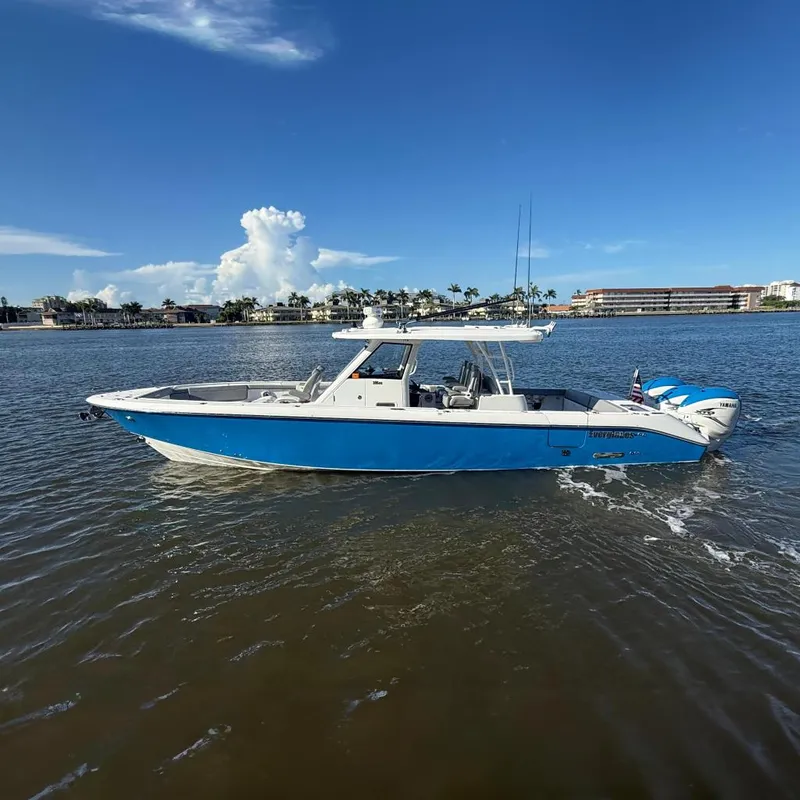 The Image of 2023 Everglades 395 Center Console boat on calm water, clear sky background. - 0