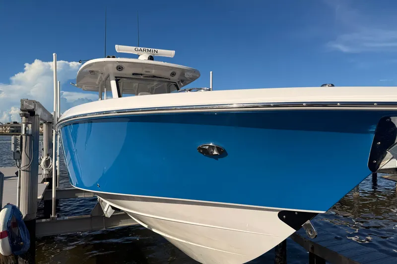 Slide: The Image of 2023 Everglades 395 Center Console boat docked, featuring a sleek blue hull. - 13