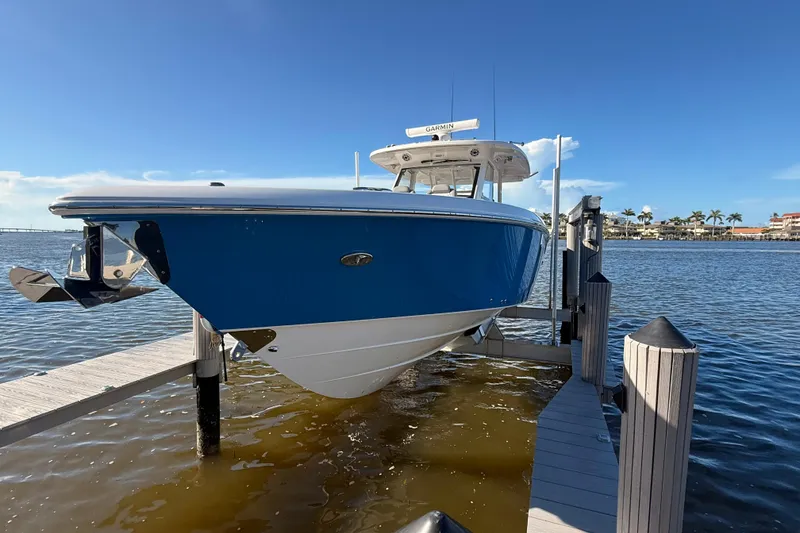 Slide: The Image of 2023 Everglades 395 Center Console boat docked by the water on a sunny day. - 16