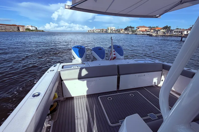 Slide: The Image of 2023 Everglades 395 Center Console boat on water, featuring dual engines and spacious deck. - 17