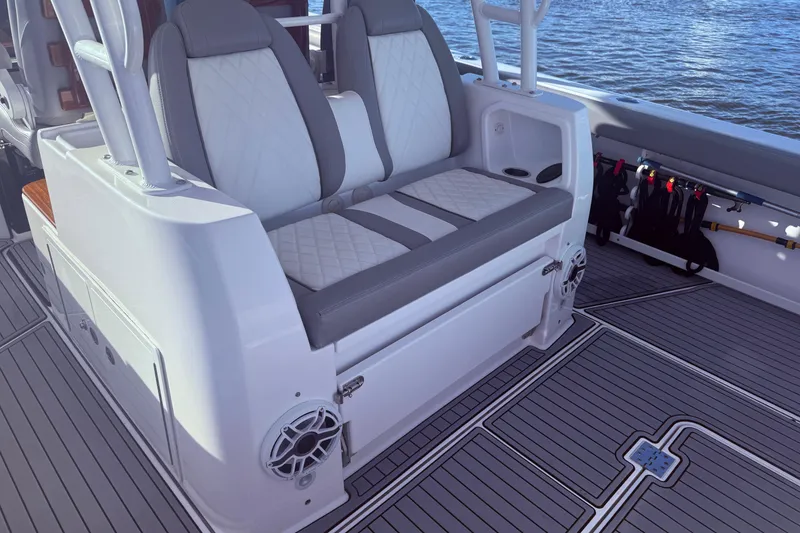 Slide: The Image of 2023 Everglades 395 Center Console boat interior with cushioned seating and rod holders. - 19
