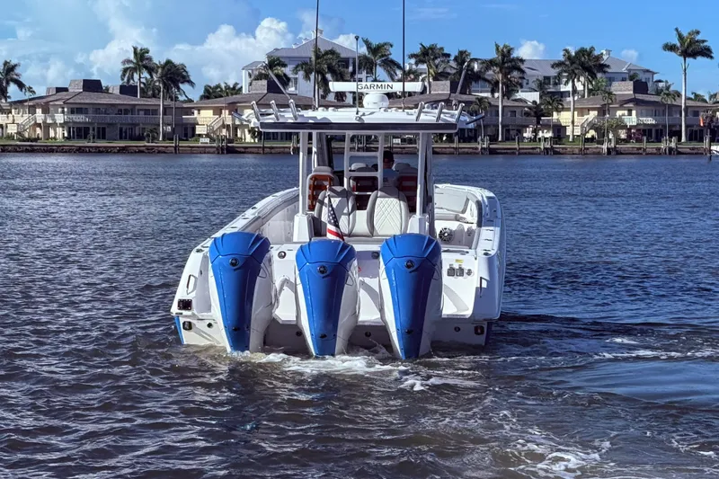Slide: The Image of 2023 Everglades 395 Center Console boat with triple engines on water. - 2