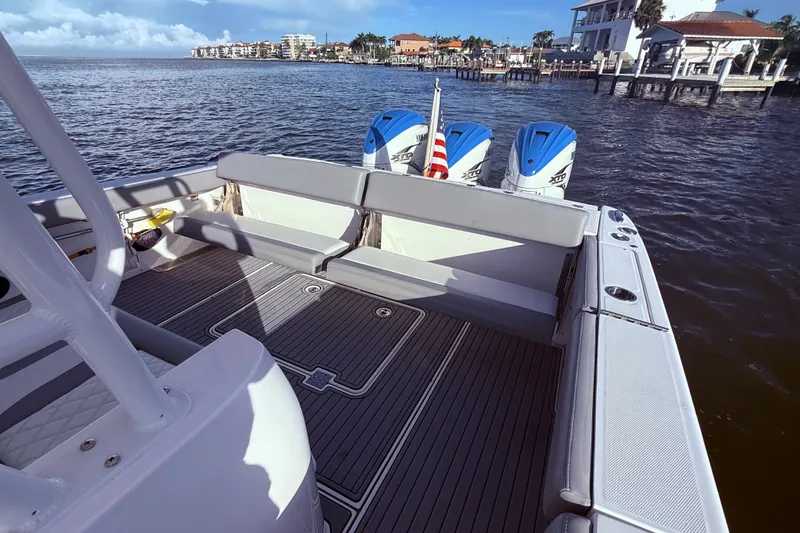 Slide: The Image of 2023 Everglades 395 Center Console boat with triple engines on a scenic waterfront. - 20