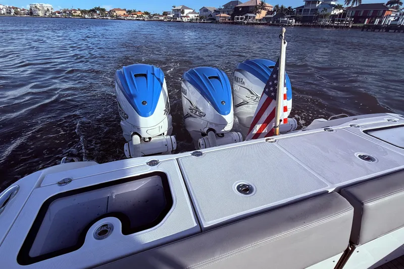 Slide: The Image of 2023 Everglades 395 Center Console with triple Yamaha engines and American flag on water. - 26