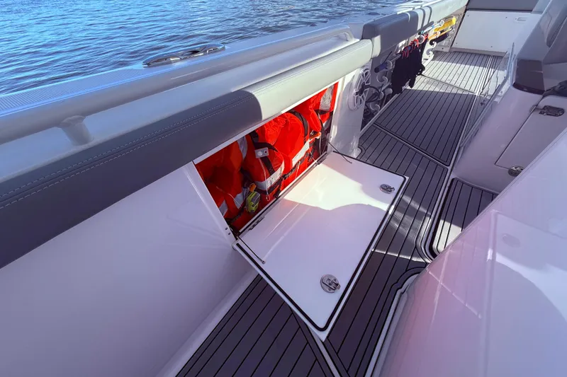 Slide: The Image of 2023 Everglades 395 Center Console boat with open storage compartment and life jackets. - 37