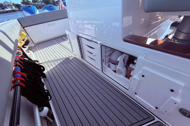 Slide: The Image of 2023 Everglades 395 Center Console boat interior with storage compartments and fishing gear. - 39